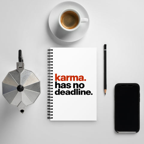White spiral notebook with rust-orange and black Karma Has No Deadline lettering centred on the front cover – ZIPZAPPA