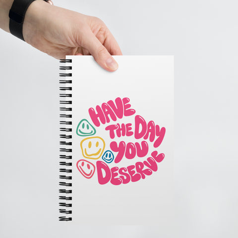 White spiral notebook with original pink Have the Day You Deserve lettering and colourful smiley faces centred on the front – ZIPZAPPA