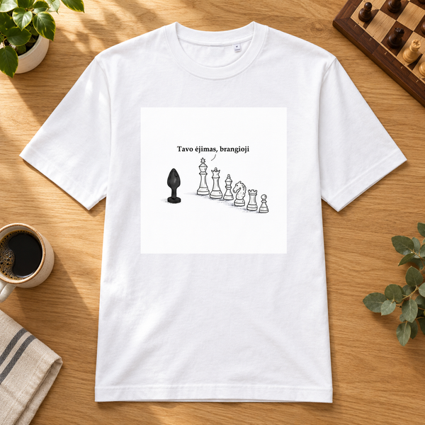 White Tavo ėjimas, brangioji heavyweight T-shirt with cheeky chess artwork, laid on an oak table beside coffee and a chessboard.