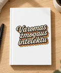 White matte hardcover journal with retro Varomas žmogaus intelektu Lithuanian lettering, on an oak desk beside a black pen and coffee.