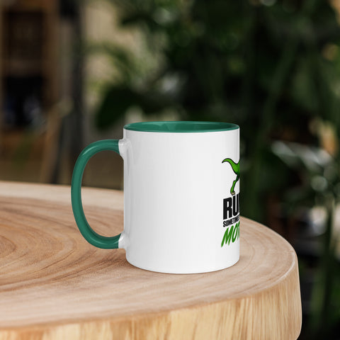 Left-side view of the 11 oz Dinosaur Motivation ceramic mug with dark green interior and handle on a round wooden table with softly blurred greenery, showing its single front design.