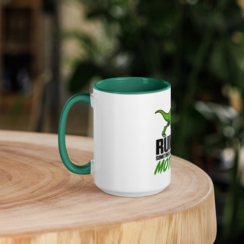 Left-side view of the 15 oz Dinosaur Motivation ceramic mug with dark green interior and handle on a round wooden table with softly blurred greenery, showing its single front design.