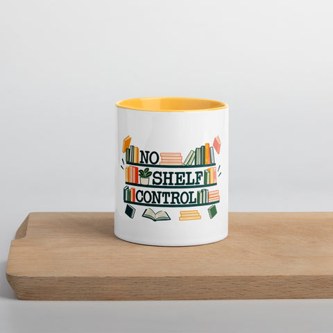 11 oz white No Shelf Control ceramic mug with golden yellow interior, rim and handle, front view on a wooden board; book illustration and green lettering printed once on the front.