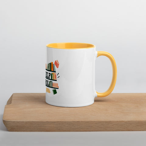 11 oz white No Shelf Control ceramic mug with golden yellow interior, rim and handle, right view on a wooden board; book illustration and green lettering printed once on the front.