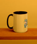 15 oz white No Shelf Control ceramic mug with golden yellow interior, rim and handle, left view on a wooden board; book illustration and green lettering printed once on the front.