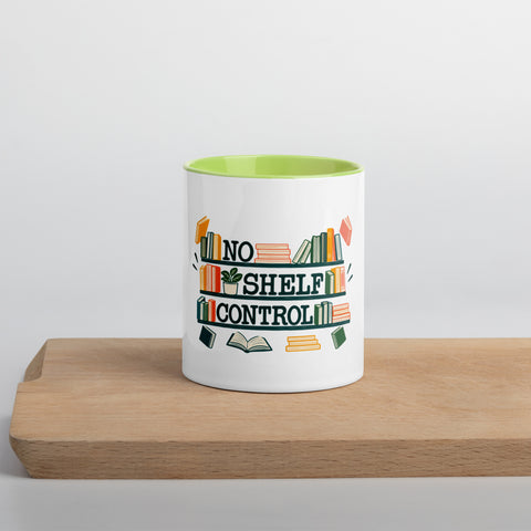 11 oz white No Shelf Control ceramic mug with green interior, rim and handle, front view on a wooden board; book illustration and green lettering printed once on the front.