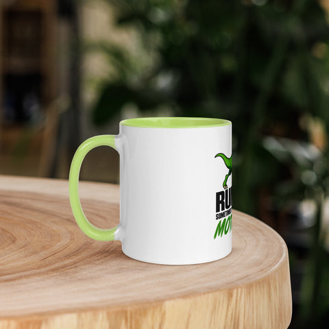 Left-side view of the 11 oz Dinosaur Motivation ceramic mug with green interior and handle on a round wooden table with softly blurred greenery, showing its single front design.