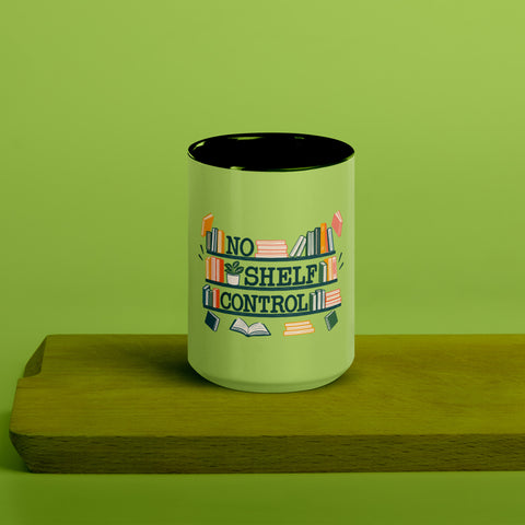 15 oz white No Shelf Control ceramic mug with green interior, rim and handle, front view on a wooden board; book illustration and green lettering printed once on the front.