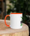 Left-side view of the 11 oz Dinosaur Motivation ceramic mug with orange interior and handle on a round wooden table with softly blurred greenery, showing its single front design.