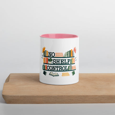 11 oz white No Shelf Control ceramic mug with pink interior, rim and handle, front view on a wooden board; book illustration and green lettering printed once on the front.