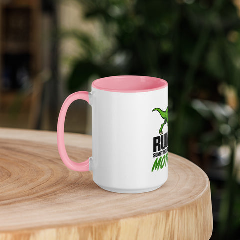 Left-side view of the 15 oz Dinosaur Motivation ceramic mug with pink interior and handle on a round wooden table with softly blurred greenery, showing its single front design.