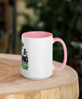 Right-side view of the 15 oz Dinosaur Motivation ceramic mug with pink interior and handle on a round wooden table with softly blurred greenery, showing its single front design.