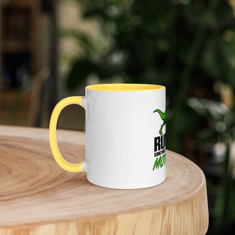 Left-side view of the 11 oz Dinosaur Motivation ceramic mug with yellow interior and handle on a round wooden table with softly blurred greenery, showing its single front design.
