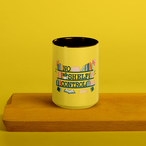 15 oz white No Shelf Control ceramic mug with yellow interior, rim and handle, front view on a wooden board; book illustration and green lettering printed once on the front.