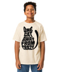 Youth model wearing a Natural One Cat Away youth classic tee, showing the black cat-shaped One Cat Away From Crazy print on the front.